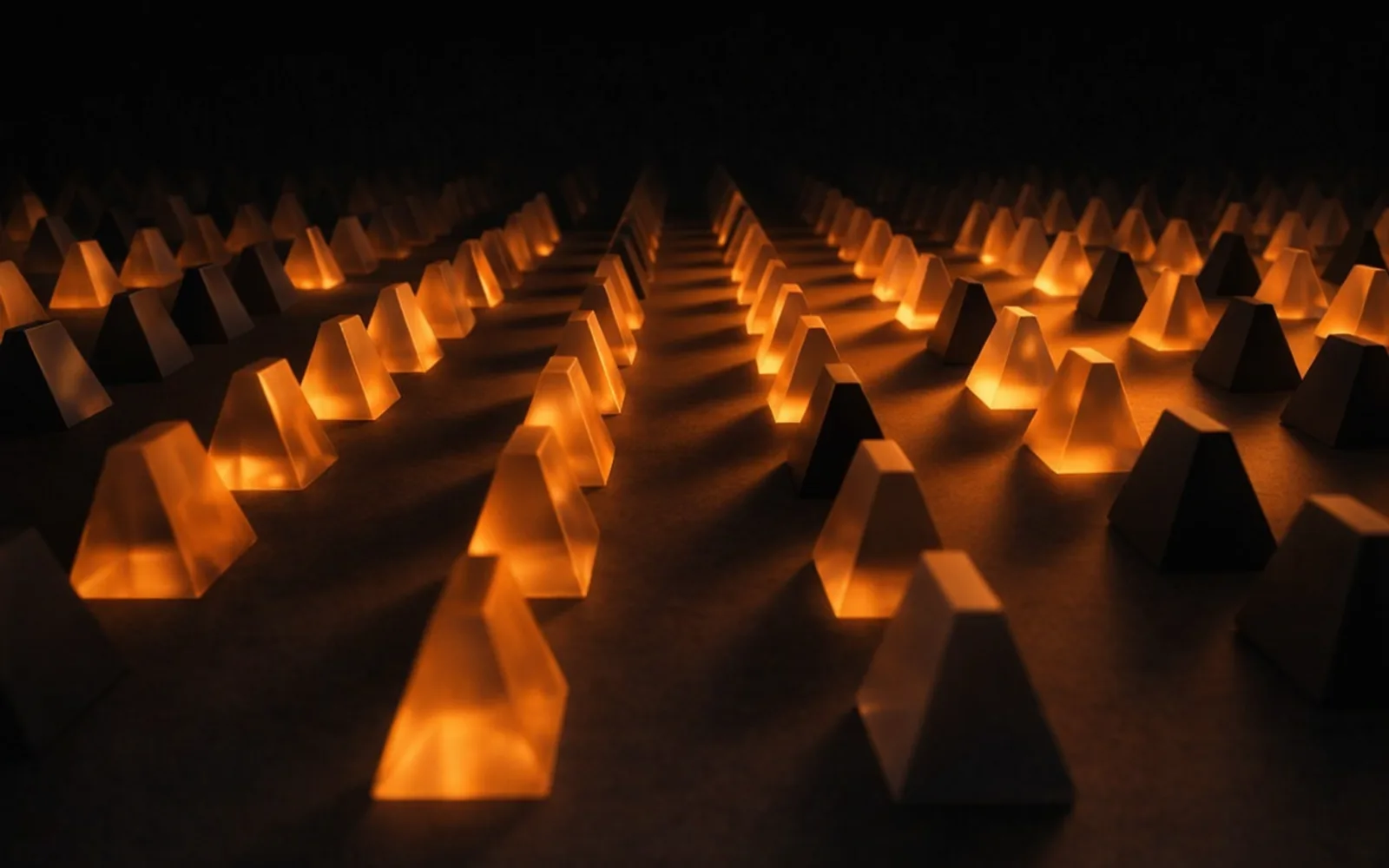 Copertina: prismi triangolari di vetro, luce ambra su fondo nero